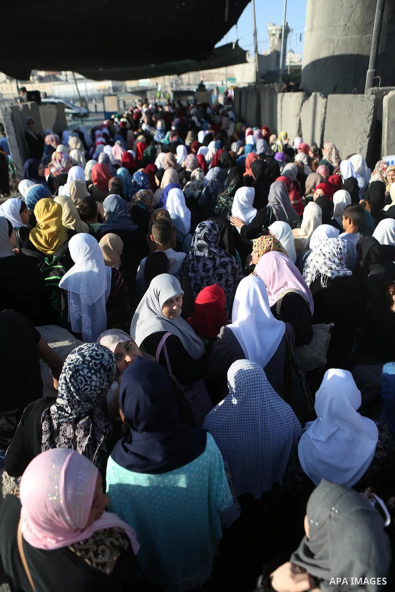Palestinians walk past Qalandia checkpoint between the West Bank city of Ramallah and Jerusalem on June 24, 2016, as they head to Jerusalem's Al-Aqsa mosque for the third Friday prayer of the holy Muslim fasting month of...
