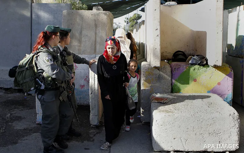 Palestinians walk through an Israeli checkpoint as they make their way to attend the third Friday prayer of the holy fasting month of Ramadan in Jerusalem's al-Aqsa mosque, in the West bank city of Bethlehem June 24, 201...