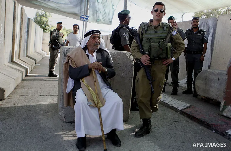 Palestinians walk through an Israeli checkpoint as they make their way to attend the third Friday prayer of the holy fasting month of Ramadan in Jerusalem's al-Aqsa mosque, in the West bank city of Bethlehem June 24, 201...