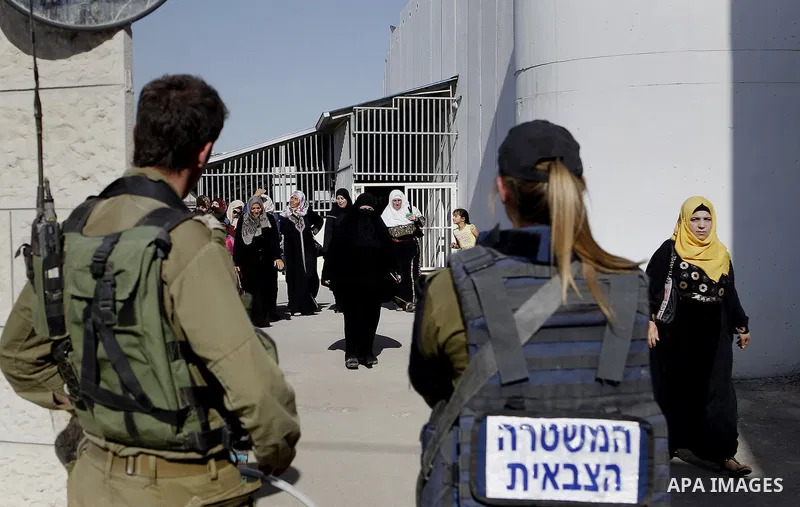 Palestinians walk through an Israeli checkpoint as they make their way to attend the third Friday prayer of the holy fasting month of Ramadan in Jerusalem's al-Aqsa mosque, in the West bank city of Bethlehem June 24, 201...