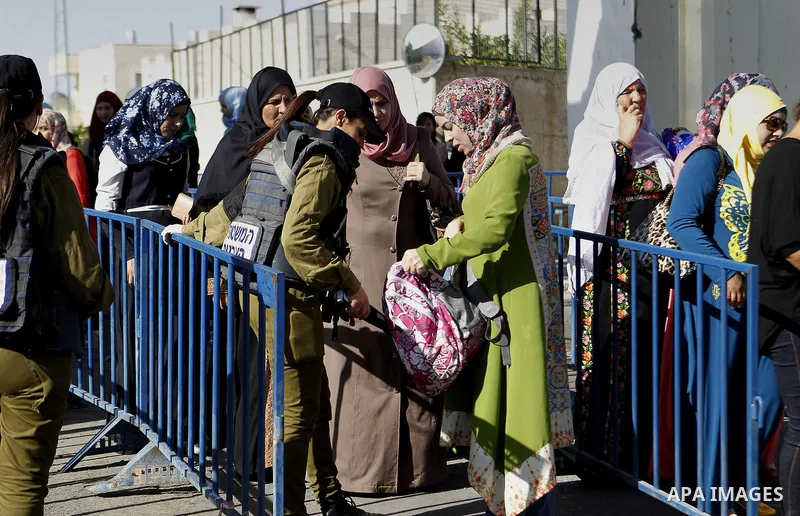 Palestinians walk through an Israeli checkpoint as they make their way to attend the third Friday prayer of the holy fasting month of Ramadan in Jerusalem's al-Aqsa mosque, in the West bank city of Bethlehem June 24, 201...