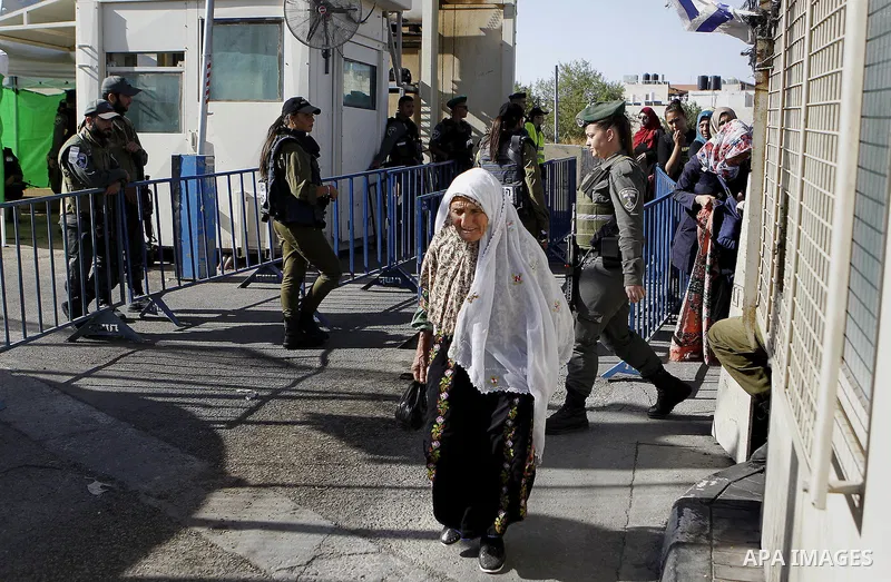 Palestinians walk through an Israeli checkpoint as they make their way to attend the third Friday prayer of the holy fasting month of Ramadan in Jerusalem's al-Aqsa mosque, in the West bank city of Bethlehem June 24, 201...