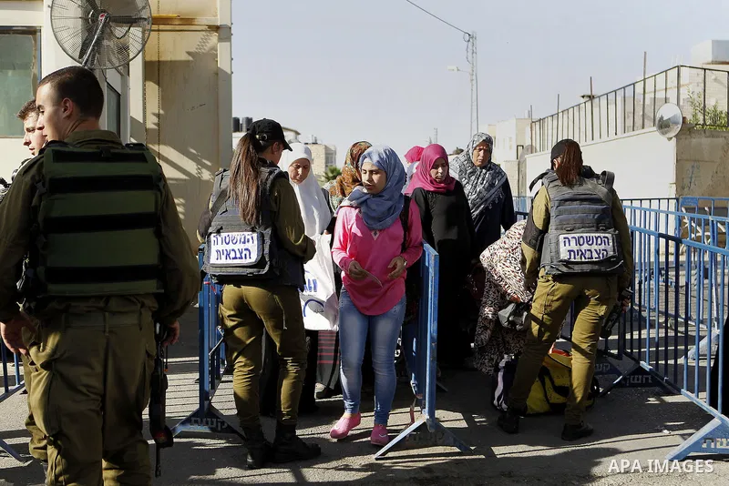 Palestinians walk through an Israeli checkpoint as they make their way to attend the third Friday prayer of the holy fasting month of Ramadan in Jerusalem's al-Aqsa mosque, in the West bank city of Bethlehem June 24, 201...