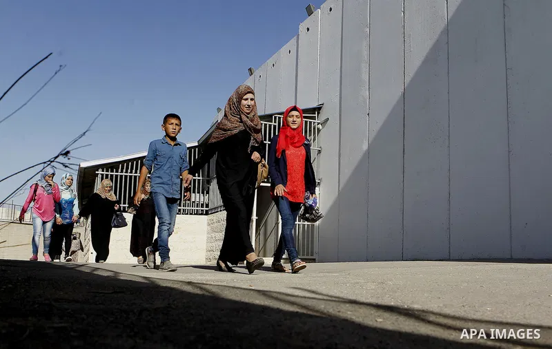 Palestinians walk through an Israeli checkpoint as they make their way to attend the third Friday prayer of the holy fasting month of Ramadan in Jerusalem's al-Aqsa mosque, in the West bank city of Bethlehem June 24, 201...