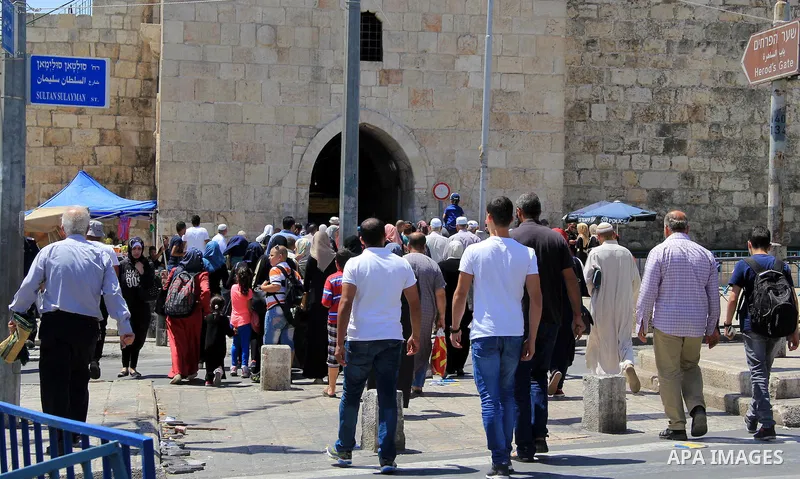 Palestinian men spray water on children to cool them down before prayers on the third Friday of the holy month of Ramadan near the Dome of the Rock, on the compound known to Muslims as Noble Sanctuary and to Jews as Temp...