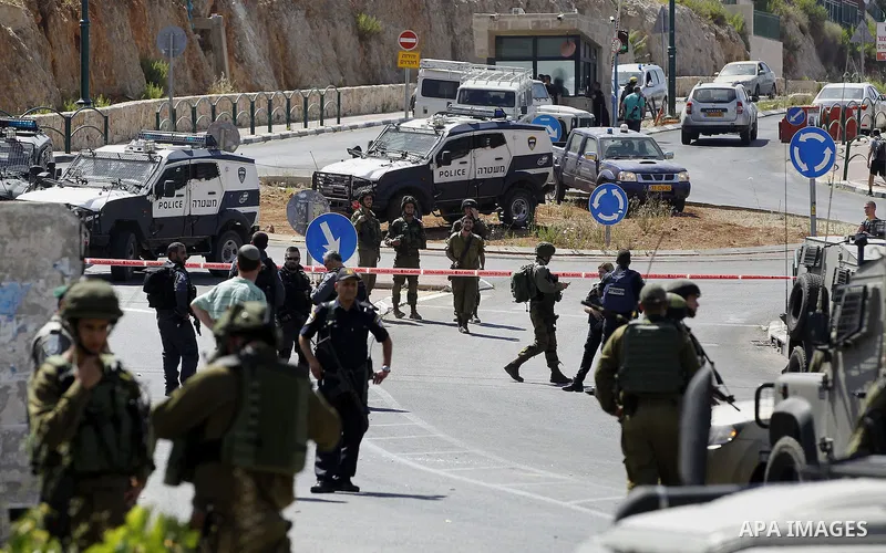 Israeli security forces gather at the scene where a female Palestinian was shot dead by Israeli troops at the entrance to Kiryat Arba near the West Bank city of Hebron June 24, 2016. Photo by Wisam Hashlamoun