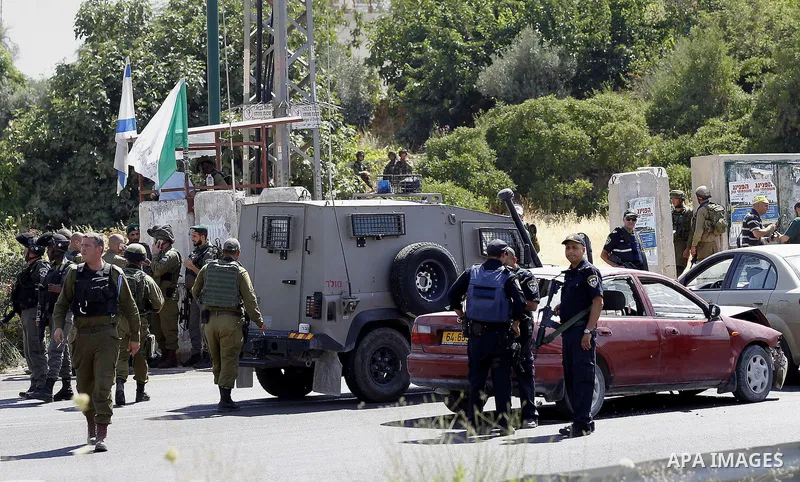 Israeli security forces gather at the scene where a female Palestinian was shot dead by Israeli troops at the entrance to Kiryat Arba near the West Bank city of Hebron June 24, 2016. Photo by Wisam Hashlamoun