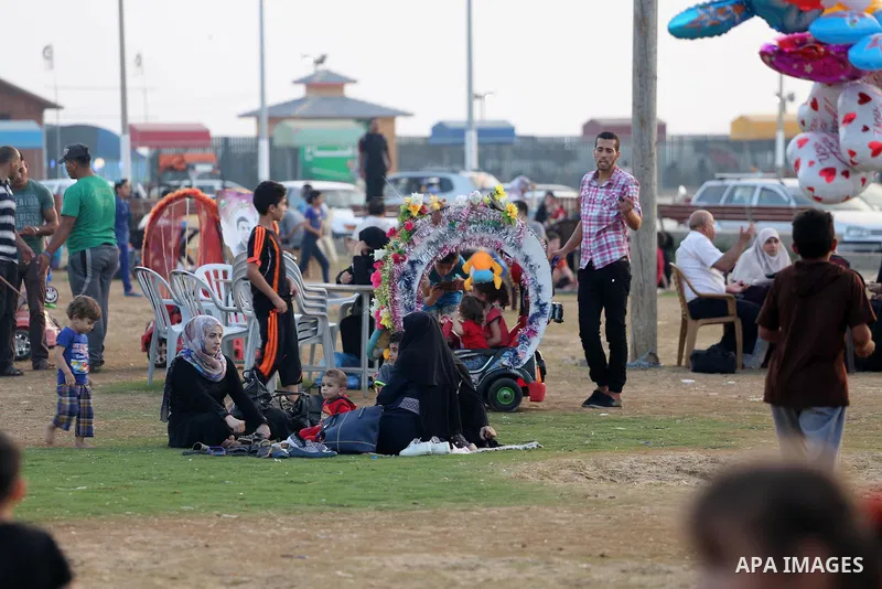 A Palestinian vendor sells ballons as Palestinian muslims prepare to break their fast on the holy fasting month of Ramadan at the beach of the Mediterranean sea on the coast of Gaza city during a hot day, on June 24, 201...
