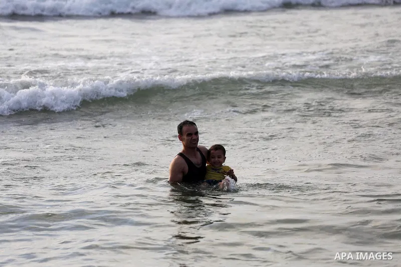 Palestinians swim in the Mediterranean sea on the coast of Gaza city during a hot day, on June 24, 2016. Photo by Mohammed Asad
