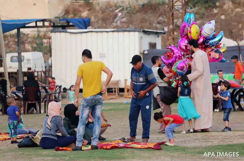A Palestinian vendor sells ballons as Palestinian muslims prepare to break their fast on the holy fasting month of Ramadan at the beach of the Mediterranean sea on the coast of Gaza city during a hot day, on June 24, 201...
