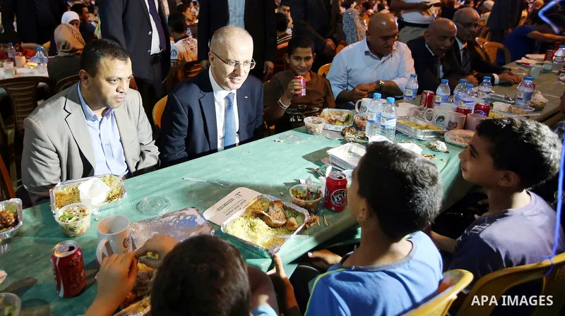 Palestinian Prime Minister Rami Hamdallah takes part during take breakfast for orphans on holy fasting month of Ramadan, at An-Najah national University, in the West Bank City of Nablus, on June 24, 2016. Photo by Prime...
