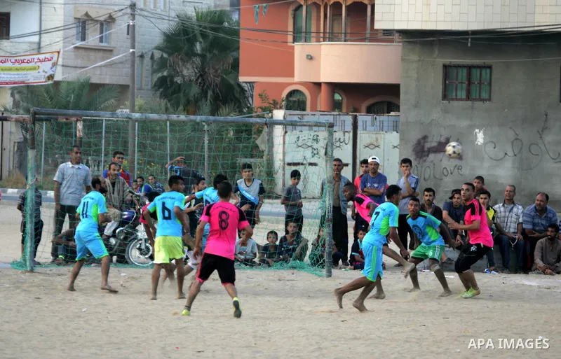 Palestinian youths play football match, at a refugee camp in Rafah, in the southern Gaza Strip, during the Muslim holy month of Ramadan on June 25, 2016. Muslims around the world abstain from food, drink and sexual inter...