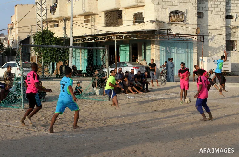 Palestinian youths play football match, at a refugee camp in Rafah, in the southern Gaza Strip, during the Muslim holy month of Ramadan on June 25, 2016. Muslims around the world abstain from food, drink and sexual inter...