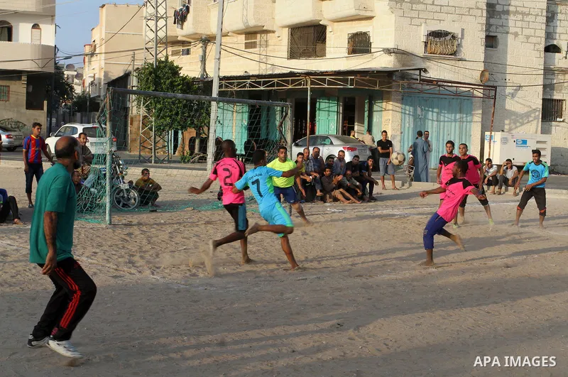 Palestinian youths play football match, at a refugee camp in Rafah, in the southern Gaza Strip, during the Muslim holy month of Ramadan on June 25, 2016. Muslims around the world abstain from food, drink and sexual inter...
