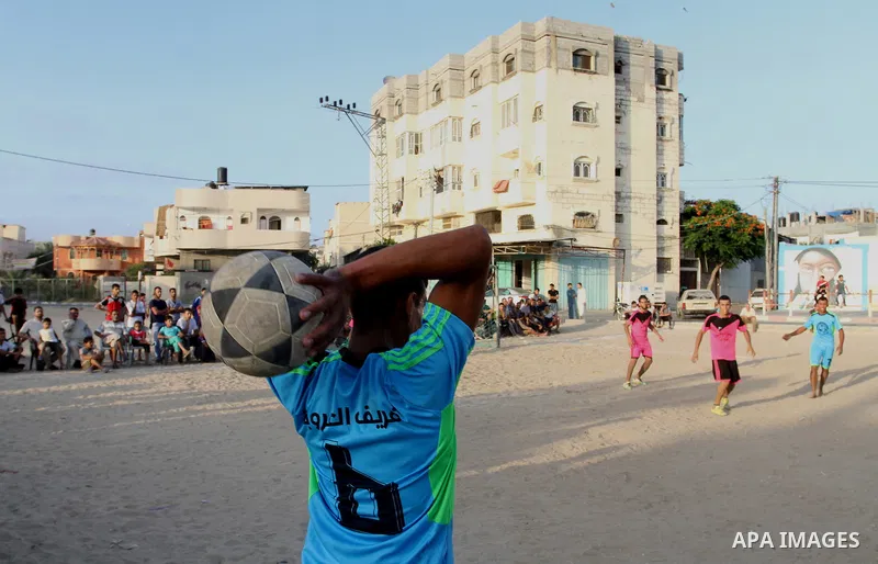 Palestinian youths play football match, at a refugee camp in Rafah, in the southern Gaza Strip, during the Muslim holy month of Ramadan on June 25, 2016. Muslims around the world abstain from food, drink and sexual inter...