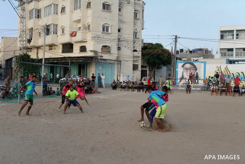 Palestinian youths play football match, at a refugee camp in Rafah, in the southern Gaza Strip, during the Muslim holy month of Ramadan on June 25, 2016. Muslims around the world abstain from food, drink and sexual inter...