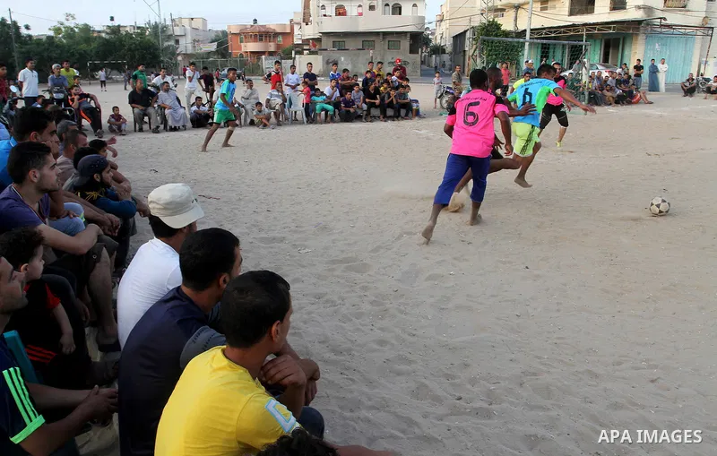 Palestinian youths play football match, at a refugee camp in Rafah, in the southern Gaza Strip, during the Muslim holy month of Ramadan on June 25, 2016. Muslims around the world abstain from food, drink and sexual inter...