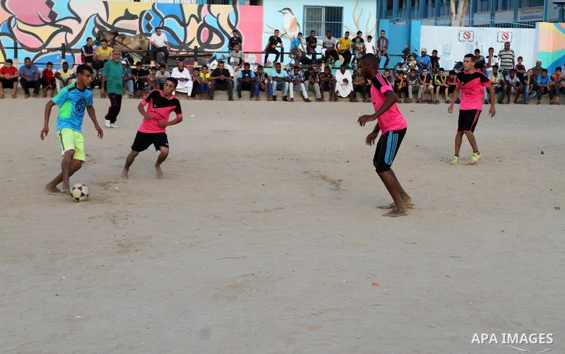 Palestinian youths play football match, at a refugee camp in Rafah, in the southern Gaza Strip, during the Muslim holy month of Ramadan on June 25, 2016. Muslims around the world abstain from food, drink and sexual inter...