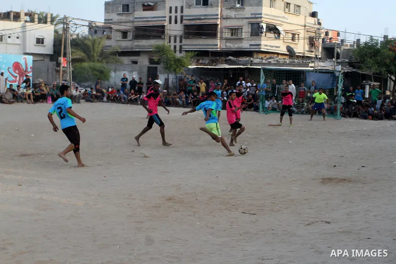 Palestinian youths play football match, at a refugee camp in Rafah, in the southern Gaza Strip, during the Muslim holy month of Ramadan on June 25, 2016. Muslims around the world abstain from food, drink and sexual inter...