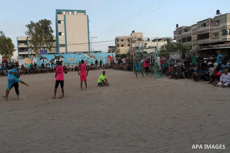 Palestinian youths play football match, at a refugee camp in Rafah, in the southern Gaza Strip, during the Muslim holy month of Ramadan on June 25, 2016. Muslims around the world abstain from food, drink and sexual inter...