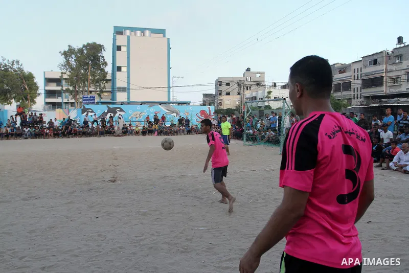 Palestinian youths play football match, at a refugee camp in Rafah, in the southern Gaza Strip, during the Muslim holy month of Ramadan on June 25, 2016. Muslims around the world abstain from food, drink and sexual inter...
