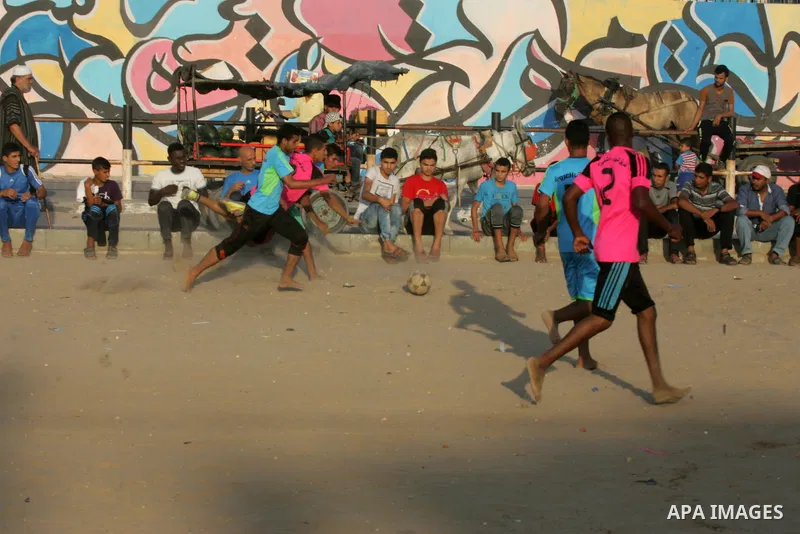 Palestinian youths play football match, at a refugee camp in Rafah, in the southern Gaza Strip, during the Muslim holy month of Ramadan on June 25, 2016. Muslims around the world abstain from food, drink and sexual inter...