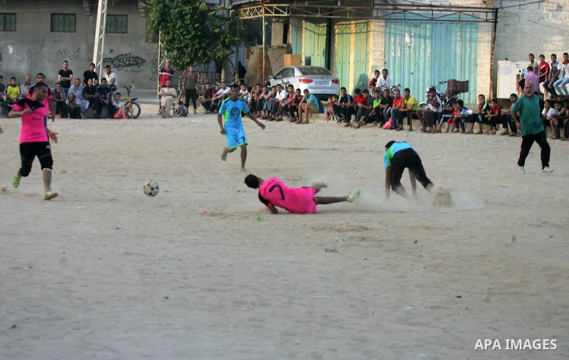 Palestinian youths play football match, at a refugee camp in Rafah, in the southern Gaza Strip, during the Muslim holy month of Ramadan on June 25, 2016. Muslims around the world abstain from food, drink and sexual inter...