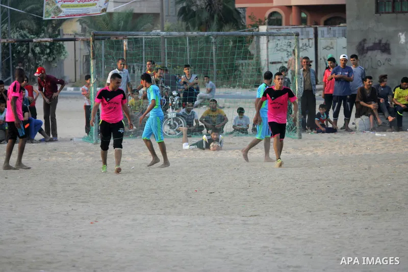 Palestinian youths play football match, at a refugee camp in Rafah, in the southern Gaza Strip, during the Muslim holy month of Ramadan on June 25, 2016. Muslims around the world abstain from food, drink and sexual inter...