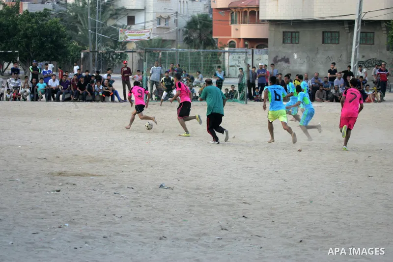 Palestinian youths play football match, at a refugee camp in Rafah, in the southern Gaza Strip, during the Muslim holy month of Ramadan on June 25, 2016. Muslims around the world abstain from food, drink and sexual inter...