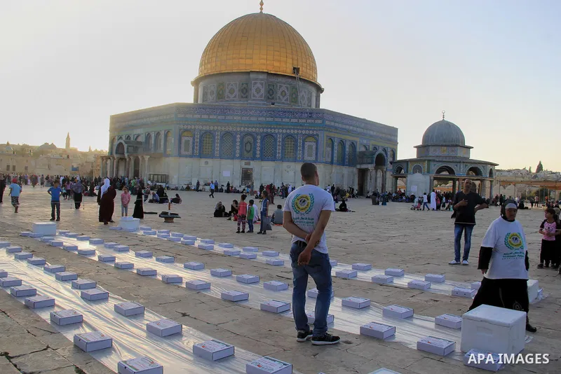 Palestinian muslims prepare to break their fast during the holy fasting month of Ramadan in front of the Dome of the Rock mosque at the al-Aqsa mosque compound, in Jerusalem's old city on June 25, 2016. Ramadan is sacred...