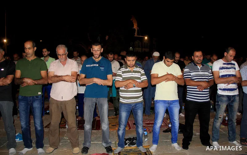 Palestinian Muslim worshippers perform "Taraweeh", nightly prayer of the month of Ramadan, in front of the Dome of the Rock mosque, in Jerusalem's old city on June 25, 2016. Ramadan is sacred to Muslims because it is dur...