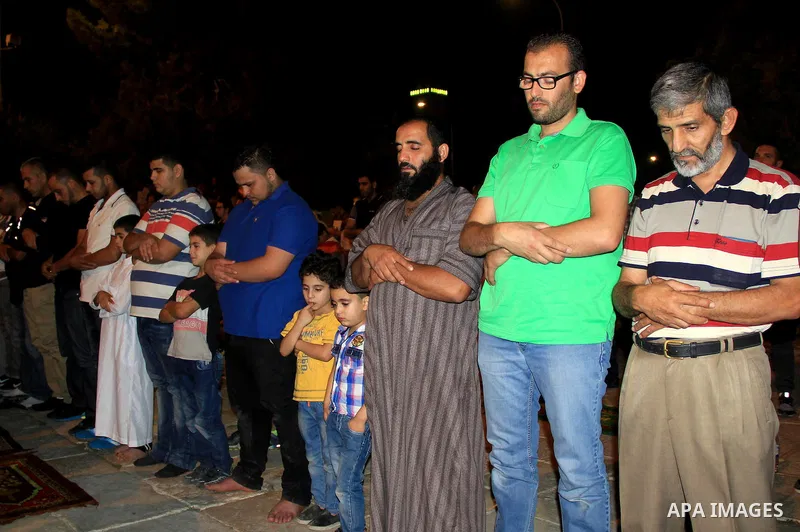 Palestinian Muslim worshippers perform "Taraweeh", nightly prayer of the month of Ramadan, in front of the Dome of the Rock mosque, in Jerusalem's old city on June 25, 2016. Ramadan is sacred to Muslims because it is dur...