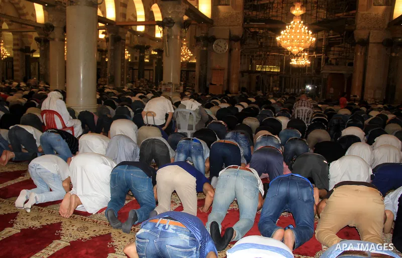 Palestinian Muslim worshippers perform "Taraweeh", nightly prayer of the month of Ramadan, in front of the Dome of the Rock mosque, in Jerusalem's old city on June 25, 2016. Ramadan is sacred to Muslims because it is dur...