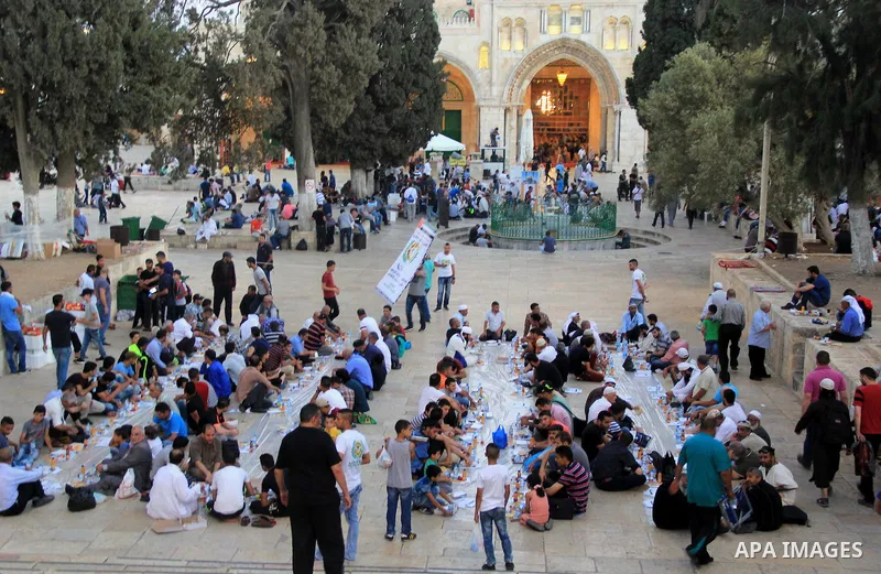 Palestinian muslims prepare to break their fast during the holy fasting month of Ramadan in front of the Dome of the Rock mosque at the al-Aqsa mosque compound, in Jerusalem's old city on June 25, 2016. Ramadan is sacred...