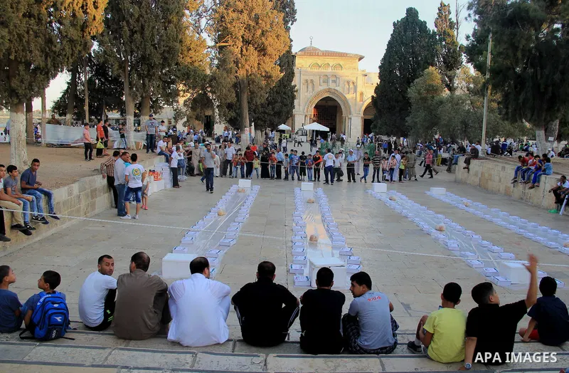 Palestinian muslims prepare to break their fast during the holy fasting month of Ramadan in front of the Dome of the Rock mosque at the al-Aqsa mosque compound, in Jerusalem's old city on June 25, 2016. Ramadan is sacred...