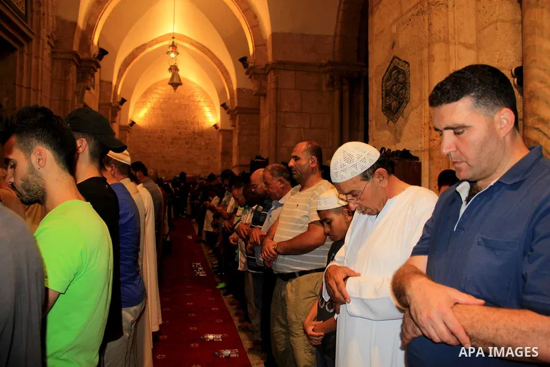 Palestinian Muslim worshippers perform "Taraweeh", nightly prayer of the month of Ramadan, in front of the Dome of the Rock mosque, in Jerusalem's old city on June 25, 2016. Ramadan is sacred to Muslims because it is dur...