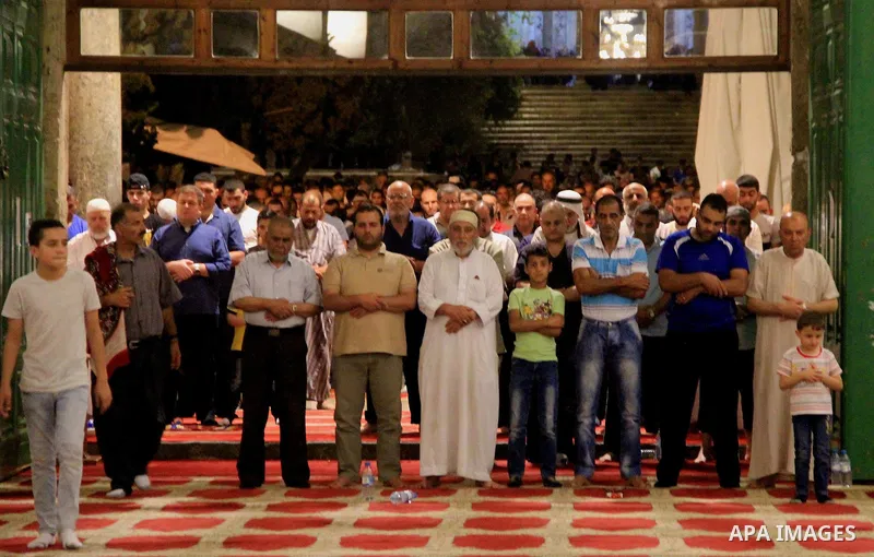 Palestinian Muslim worshippers perform "Taraweeh", nightly prayer of the month of Ramadan, in front of the Dome of the Rock mosque, in Jerusalem's old city on June 25, 2016. Ramadan is sacred to Muslims because it is dur...