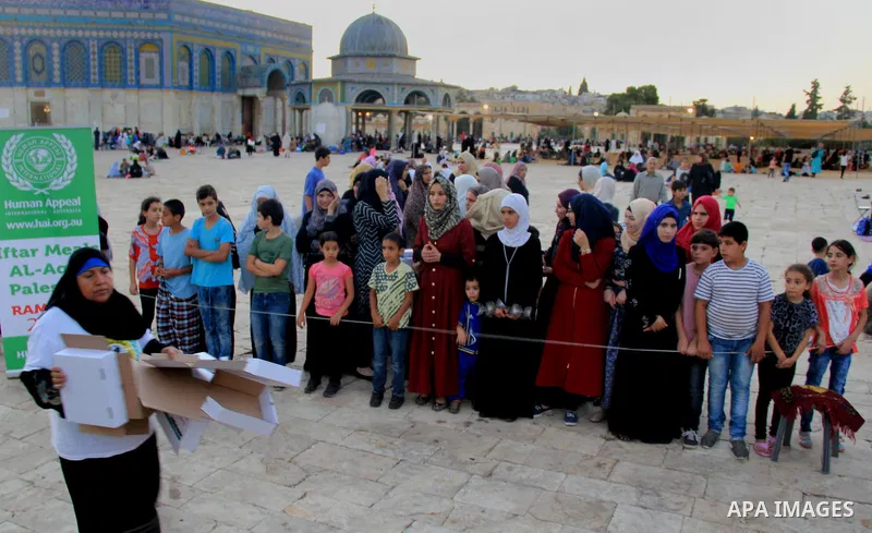 Palestinian muslims prepare to break their fast during the holy fasting month of Ramadan in front of the Dome of the Rock mosque at the al-Aqsa mosque compound, in Jerusalem's old city on June 25, 2016. Ramadan is sacred...