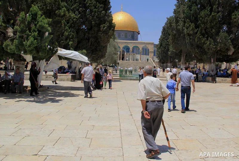 Palestinian men walk outside Jerusalem's al-Aqsa mosque after clashes erupted at the compound between Palestinians and Israeli police on June 26, 2016 during the holy month of Ramadan. Israeli police at Jerusalem's Al-Aq...