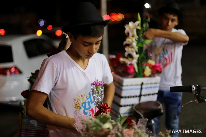 Palestinian youths wander on colorful bicycles and sell flowers at street in Gaza city, on June 26, 2016. Unemployment in the Palestinian enclave of Gaza has risen dramatically to reach around 45 percent, one of the high...
