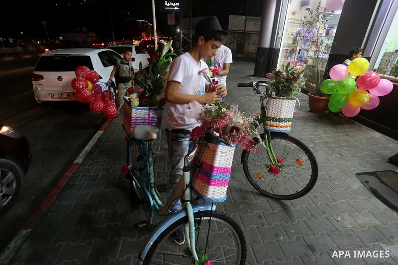 Palestinian youths wander on colorful bicycles and sell flowers at street in Gaza city, on June 26, 2016. Unemployment in the Palestinian enclave of Gaza has risen dramatically to reach around 45 percent, one of the high...
