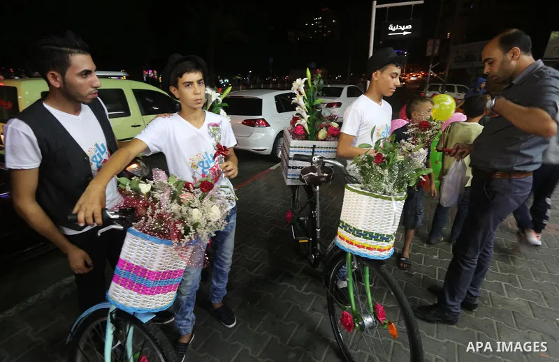 Palestinian youths wander on colorful bicycles and sell flowers at street in Gaza city, on June 26, 2016. Unemployment in the Palestinian enclave of Gaza has risen dramatically to reach around 45 percent, one of the high...
