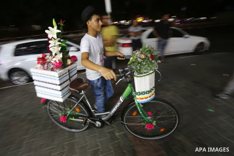 Palestinian youths wander on colorful bicycles and sell flowers at street in Gaza city, on June 26, 2016. Unemployment in the Palestinian enclave of Gaza has risen dramatically to reach around 45 percent, one of the high...