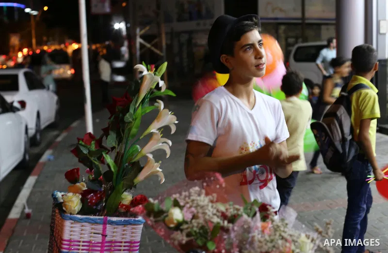 Palestinian youths wander on colorful bicycles and sell flowers at street in Gaza city, on June 26, 2016. Unemployment in the Palestinian enclave of Gaza has risen dramatically to reach around 45 percent, one of the high...