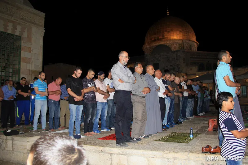 Palestinian Muslim worshippers perform "Taraweeh", nightly prayer of the month of Ramadan, in front of the Dome of the Rock mosque, in Jerusalem's old city on June 26, 2016. Ramadan is sacred to Muslims because it is dur...