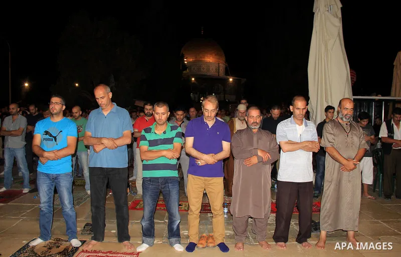 Palestinian Muslim worshippers perform "Taraweeh", nightly prayer of the month of Ramadan, in front of the Dome of the Rock mosque, in Jerusalem's old city on June 26, 2016. Ramadan is sacred to Muslims because it is dur...