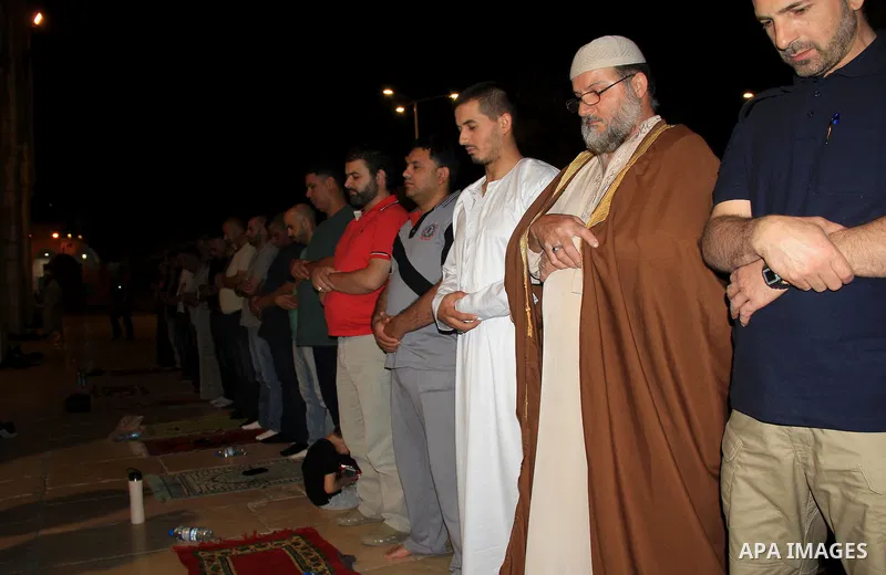 Palestinian Muslim worshippers perform "Taraweeh", nightly prayer of the month of Ramadan, in front of the Dome of the Rock mosque, in Jerusalem's old city on June 26, 2016. Ramadan is sacred to Muslims because it is dur...