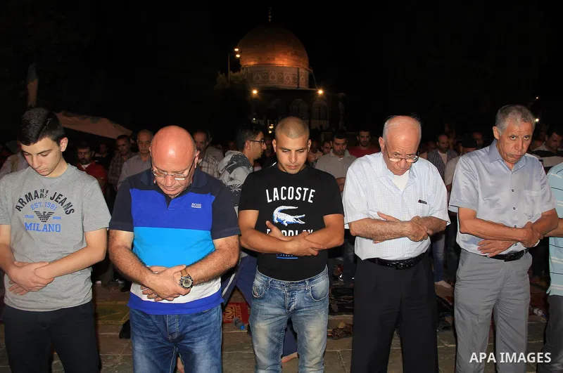 Palestinian Muslim worshippers perform "Taraweeh", nightly prayer of the month of Ramadan, in front of the Dome of the Rock mosque, in Jerusalem's old city on June 26, 2016. Ramadan is sacred to Muslims because it is dur...