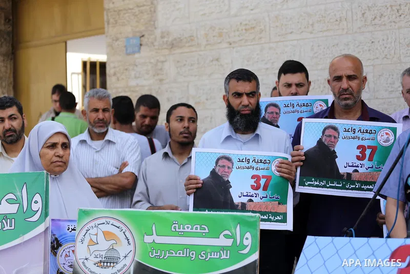 Palestinians take part in a protest demanding release the prisoners in Israeli jails, in front of Red cross office, in Gaza city, on June 27, 2016. Photo by Mohammed Asad