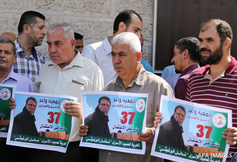 Palestinians take part in a protest demanding release the prisoners in Israeli jails, in front of Red cross office, in Gaza city, on June 27, 2016. Photo by Mohammed Asad